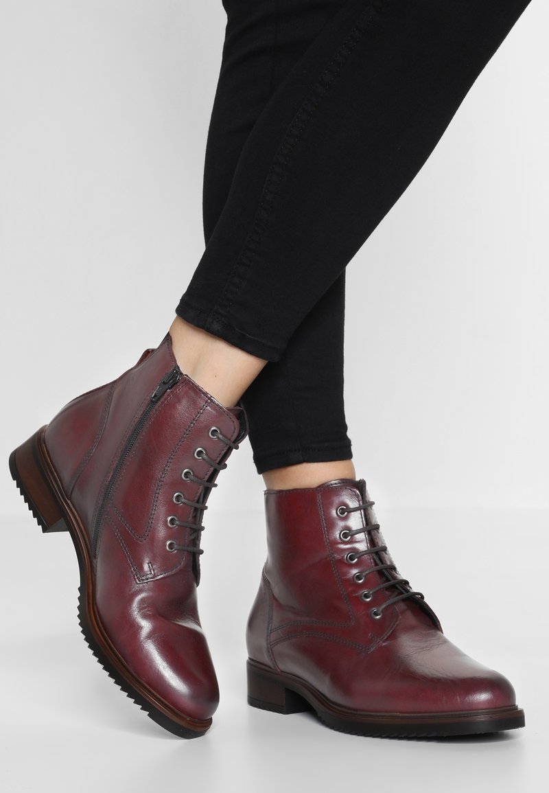 Bordowe skórzane botki na kostkę z okrągłym noskiem, sznurowadłem i zapięciem na zamek, oraz teksturowaną podeszwą. Posiadają akcenty w postaci przeszyć dla większego detalu.