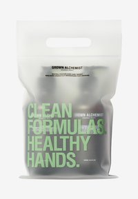 Transparente Plastikbeutel mit zwei dunklen Flaschen. Text in Grün und Schwarz: "REINE FORMULIERUNGEN. GESUNDE HÄNDE." und Produktdetails.