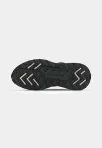 Black sneaker sole with textured rubber for traction, featuring zigzag patterns and the Lacoste logo embossed in the center.