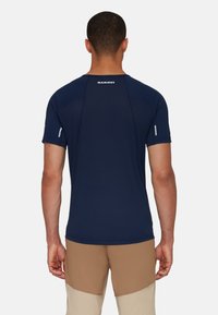 Navyblauw shirt met korte mouwen van lichtgewicht materiaal, met een ronde hals en een subtiele logo op de achterkant, in een getailleerd ontwerp.