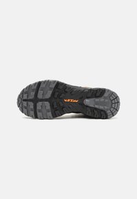 Black and gray rubber sole with deep traction patterns, featuring orange branding. Sturdy, textured surface for grip and durability.