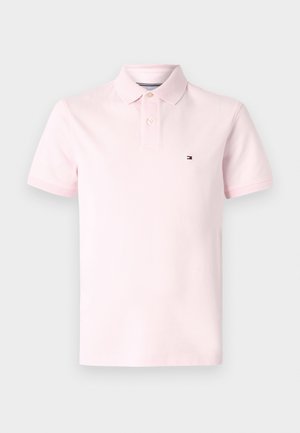 Light pink polo shirt made of cotton, featuring a classic collar, short sleeves, three-button placket, and small logo on the chest.