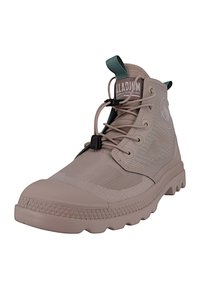 Stivale alto beige realizzato in gomma texturizzata e rete. Presenta una punta arrotondata, chiusura con lacci e un’etichetta verde sul collo.