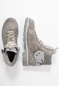 Botas de invierno en gamuza gris con cordones, con cuellos de tobillo acolchados y acanalados, suelas de goma duraderas y ojales de metal, mostradas desde vistas superiores y laterales.