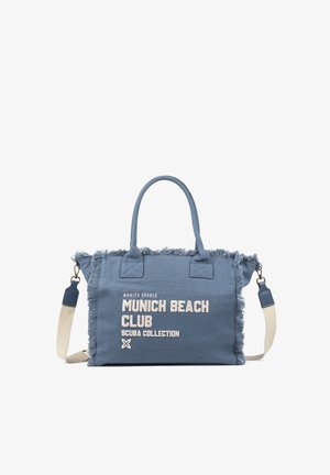 Bolsa tote de lona azul con bordes deshilachados, asas dobles, correa beige desmontable y texto blanco que dice "Munich Beach Club Scuba Collection."