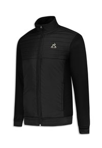 Giacca atletica nera con zip frontale. Presenta una parte superiore trapuntata, maniche testurizzate e un logo sul lato sinistro del petto.