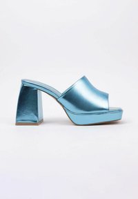 Mules plate-forme métalliques bleus avec un talon bloc, présentant une pointe ouverte et une large sangle supérieure. La surface a une finition lisse et brillante.