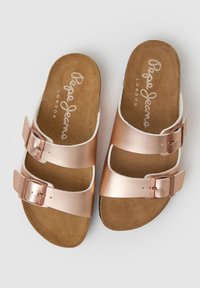 Koperkleurige metallic slippers met twee verstelbare banden, een gestructureerde bruine voetbed en een witte rand, met het merk "Pepe Jeans London".