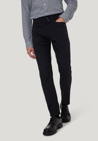 Schwarze, schlank geschnittene Chinos aus einem Baumwoll-Mischgewebe, mit klassischem Fünf-Taschen-Design, glattem Bund und einer angenehmen Textur.