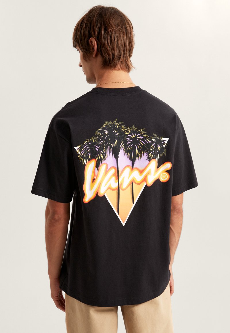Camiseta de algodón negra con un gráfico colorido de palmeras y el logo de Vans en un degradado de naranja a amarillo dentro de un diseño triangular.