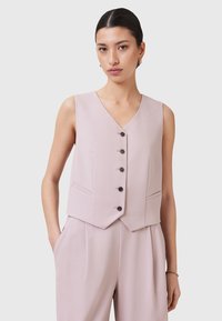 Gilet senza maniche rosa chiaro con scollatura a V, dotato di bottoni frontali e tasche laterali. Tessuto liscio con una vestibilità sartoriale.