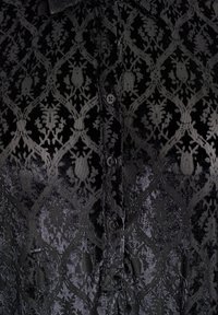 Czarna koszula z guzikami wykonana z fakturowanej tkaniny z kwiatowym i owadzim wzorem, gładka powierzchnia i subtelny połysk.