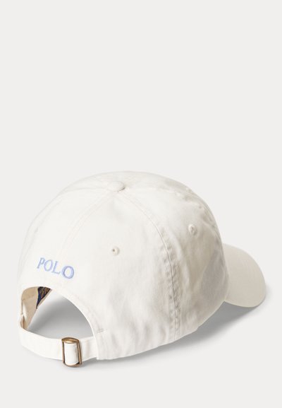 Bela bomba kapa iz bombaža z nastavljivim trakom in svetlo modro vezenino "POLO" na zadnji strani, prikazana iz zadnjega bočnega kota.