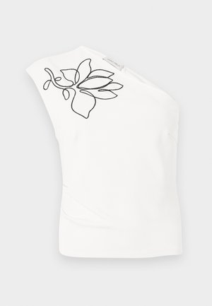 Λευκό ασύμμετρο αμάνικο τοπ με μαύρο κεντητό λουλουδένιο σχέδιο κοντά στον ώμο και μια μικρή υφασμάτινη ετικέτα επωνυμίας.