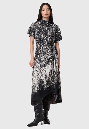 Zwart-witte jurk met luipaardprint, korte mouwen, asymmetrische zoom, geraffineerd detail bij de taille en een soepele stoftextuur.