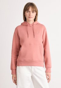 Felpa rosa con cappuccio, tasca anteriore e polsini a coste. Lacci argentati e un piccolo dettaglio del logo vicino al petto.