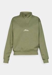 Olivově zelená mikina na zip s límečkem a žebrovanými manžetami. Na hrudi je bílý vyšívaný logo. Jemná, strukturovaná tkanina.