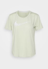 Camiseta deportiva verde claro hecha de tejido suave, con un logo blanco de Nike en la parte delantera, cuello redondo y mangas cortas.