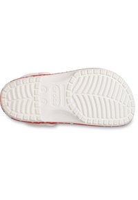 Sandalia Crocs, suela blanca con agarre texturizado, parte superior roja brillante con un diseño estampado y orificios de ventilación laterales.