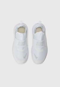 White athletic shoes with a mesh upper and rubber sole. Features a prominent midfoot strap and a small logo on the side. Interior has textured lining.