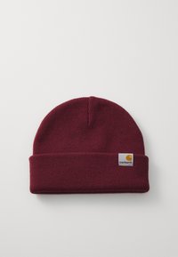 Burgundy knit beanie hat with a folded cuff and a square leather logo patch featuring a yellow emblem and text on the front.