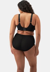 Ensemble de soutien-gorge noir et de culottes taille haute. Le soutien-gorge possède des bretelles réglables et une fermeture à crochets. Les culottes ont une finition lisse et texturée.