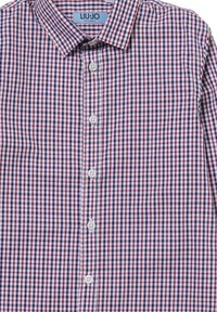 Camicia con bottoni caratterizzata da un piccolo motivo a quadri in rosso, bianco e blu navy. Realizzata in un tessuto con una superficie liscia e un colletto classico.