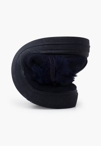 Scarpa nera con design arrotondato, caratterizzata da un morbido rivestimento peloso e una cerniera laterale. La suola ha una texture antiscivolo per migliorare la trazione.