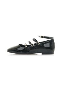 Mocasines de charol negro con puntera puntiaguda, que cuentan con tres correas ajustables con hebillas de metal a lo largo del empeine y una correa en el tobillo.