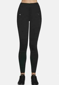 Czarne legginsy wykonane z elastycznego materiału z elastycznym pasem w talii, z dwoma kieszeniami na zamek błyskawiczny oraz poziomymi prążkowaniami na nogawkach.