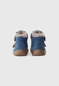 Blauwe suède enkellaarsjes met beige bontvoering, voorzien van twee verstelbare banden, een ronde neus en een rubberen zool.