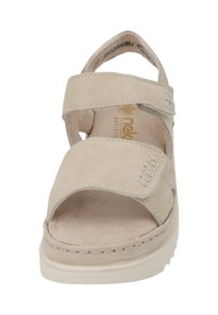 Ljusbeige sandal med två justerbara remmar, öppen tå-design, vadderad innersula och sydda detaljer längs sulan.