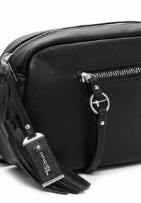 Sort tekstureret læder crossbody-taske med sølvlynlås, rundt metalringsdetalje og dekorativ frynse mærket "Tamaris".