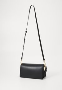 Svart lærcrossbody-veske med glatt tekstur, rektangul�ær form, justerbar stropp og detaljer i gulltone.
