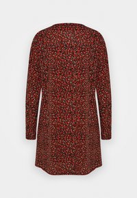 Tunique à manches longues rouge avec imprimé floral, dotée d'un col rond et d'une coupe décontractée. Le tissu présente une texture lisse avec des accents foncés.