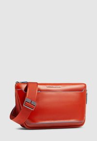 Borsa a tracolla in pelle rossa con chiusura a zip, caratterizzata da accenti blu e una tracolla regolabile resistente, progettata per un uso contemporaneo.