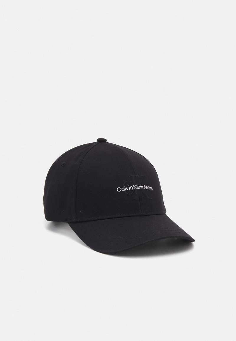 Black cotton baseball cap featuring a curved brim and embroidered "CalvinKleinJeans" logo in white on the front. Adjusts at the back.