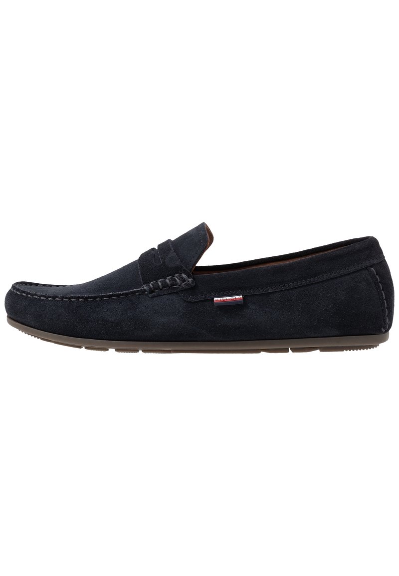 Mocassins pour homme en daim noir avec bout rond, détails cousus, talon bas et petit logo en tissu sur le côté.
