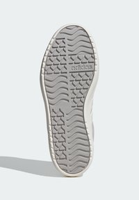 Grå gummisula med texturerade mönster, med en vågig design och diamantformade accenter. Märkt med "adidas"-logotyp.