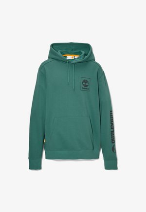 Sweat à capuche Timberland vert avec poche avant, capuche à cordon, petit logo sur la poitrine et marquage Timberland sur la manche gauche.