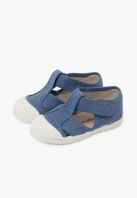Scarpe in tessuto blu con design a cinturino incrociato, punta in gomma bianca e parte superiore in morbido tessuto testurizzato. Chiusura sul retro con elastico per una vestibilità ottimale.