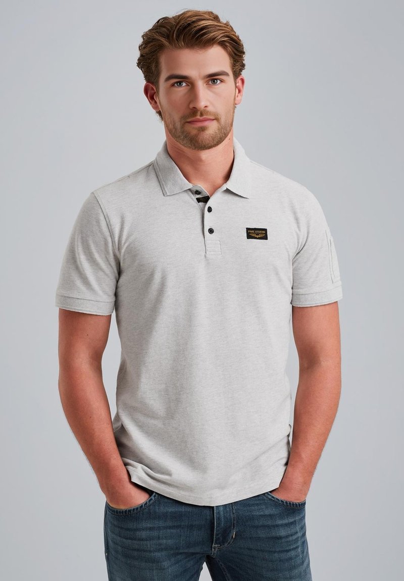 Polo grigio realizzato in misto cotone, con colletto classico, tre bottoni e un piccolo logo nero ricamato sul lato sinistro del petto.