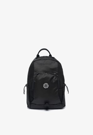 Zaino compatto nero con tessuto strutturato, tasca frontale con zip, manico superiore, anelli laterali e patch con logo circolare sulla tasca frontale.