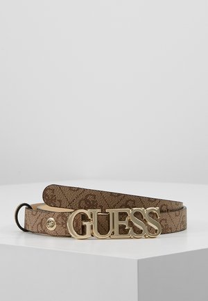 Bruine riem met patroon opgerold op een witte ondergrond met grote gouden GUESS-logo gesp en klein rond gouden embleem vlakbij het uiteinde.