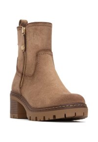 Stivaletti alla caviglia in suede marrone con zip laterale, tacco a blocco e suola testurizzata. Presentano dettagli cuciti e un'impugnatura sul retro.