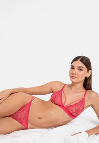 Roze kanten bh- en slipset met bloemenborduursels, driehoekige cups, dunne bandjes en een doorzichtige textuur.