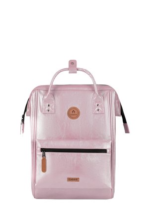 Quadratisch geformter rosa Rucksack mit vorderer Reißverschlusstasche, Tragegriff oben und Markenlogos auf der Vorderseite.