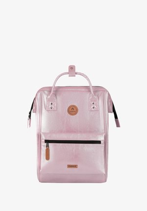 Square-shaped pink backpack with front zip pocket, top handle, and brand logos on front panel.