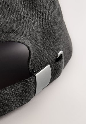 Mørkegrå baseballkasket lavet af tekstureret stof. Har en metaljusterbar rem og en buet skygge. Nærbillede af den bageste del.