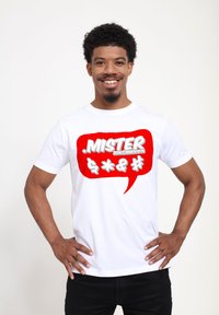 Hvid bomulds t-shirt med et stort rødt taleboble grafik. Teksten inkluderer " .MISTER" og symboler. Korte ærmer, rund hals design.